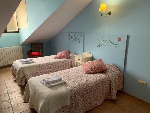 a bedroom with two beds with pink sheets at Vista Bella Segovia in Tizneros