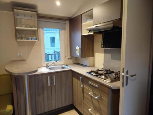 una piccola cucina con lavello e fornello di Mobil-home 6 places dans camping 4 étoiles a Lit-et-Mixe