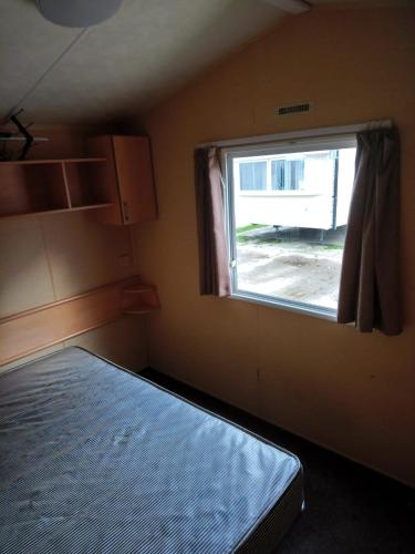 a small room with a bed and a window at The Franklin in Saint Osyth