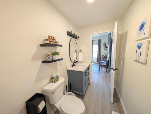 ein Badezimmer mit Toilette, Waschbecken und Spiegel in der Unterkunft Modern Norwalk Retreat with 2 King Suites in Norwalk