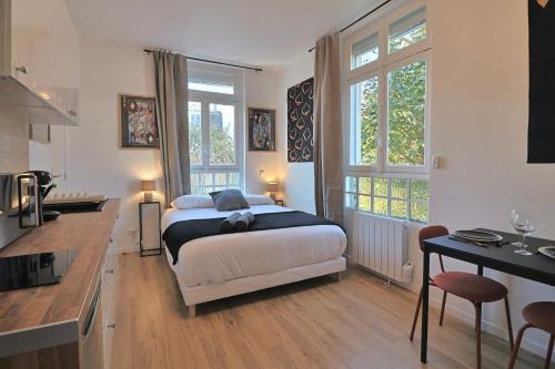 a bedroom with a bed and a kitchen with a table at SC4 - Studio 2e étage - Résidence Casino du Lac in Enghien-les-Bains