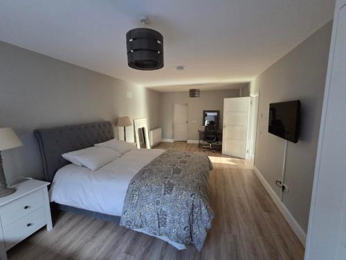 Un dormitorio con una cama grande y un televisor. en Kilgar gardens, en Kilcock