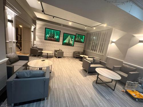 a living room with couches and tables and chairs at Royal Hotel, Bar & Grill in Purfleet