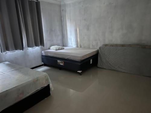 a small room with two beds and a window at Cada da lanny in Camaçari