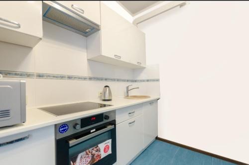 a kitchen with white cabinets and a sink at Ліфт, Вода, Опалення, WiFi працює завжди Видова Квартира, Позняки! in Kyiv