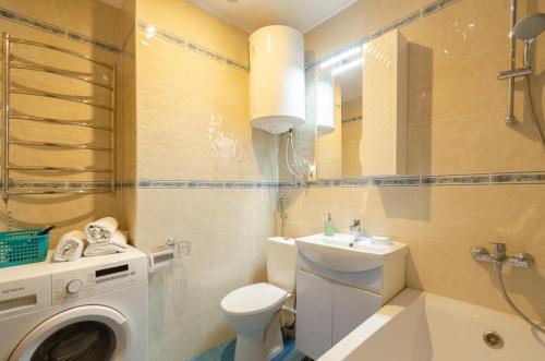 a bathroom with a toilet sink and a washing machine at Ліфт, Вода, Опалення, WiFi працює завжди Видова Квартира, Позняки! in Kyiv