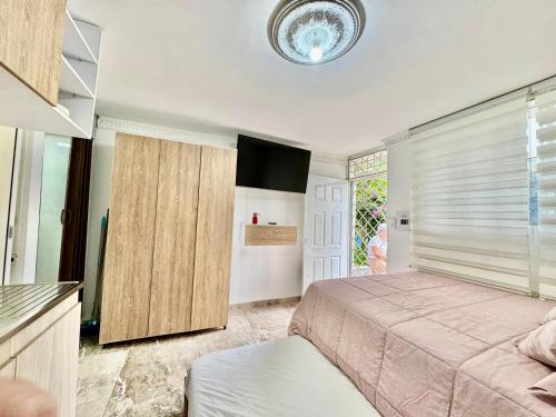 a bedroom with a bed and a television in it at Acogedor studio frente al parque - Cerca de todo in Floridablanca