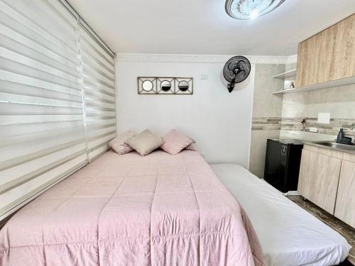 a bedroom with a pink bed in a room at Acogedor studio frente al parque - Cerca de todo in Floridablanca