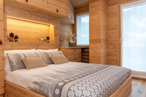 a bedroom with a bed in a wooden room at Alpine Nest in Rocca Pietore