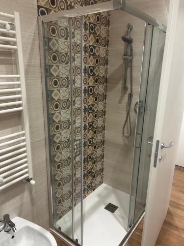 a shower with a glass door next to a sink at La Dimora di Bacco in Sannicandro di Bari