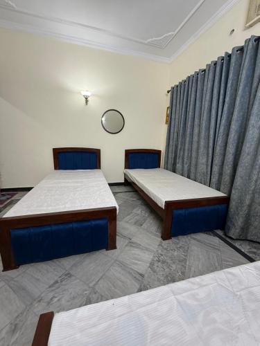 ein Zimmer mit zwei Betten und einem Vorhang in der Unterkunft Professional lodges in Islamabad
