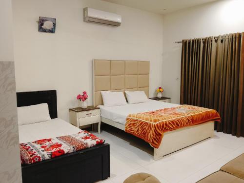 ein Hotelzimmer mit zwei Betten und einem Fenster in der Unterkunft Professional lodges in Islamabad