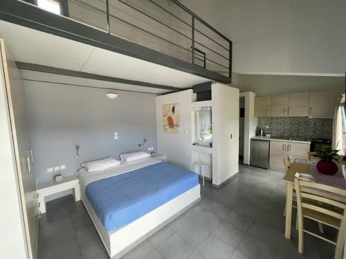 Un dormitorio con una cama grande y una cocina. en Zathea Apartments, en Agia Pelagia - Citera
