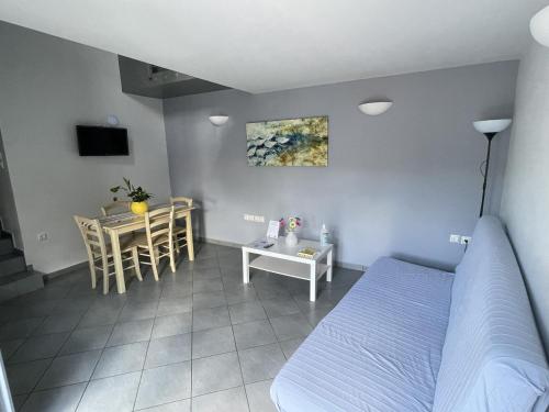 Un dormitorio con una cama y una mesa y un comedor. en Zathea Apartments, en Agia Pelagia - Citera