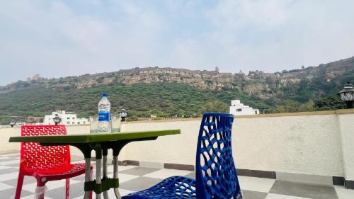 a table and chairs with a view of a mountain at legacy of chittorgarh in Chittaurgarh