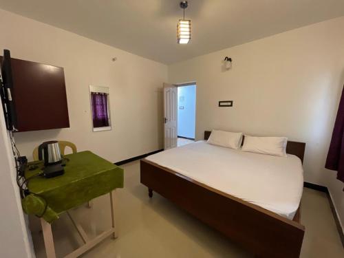 a bedroom with a large bed and a television at Radiant Hill Homestay in Kodaikānāl