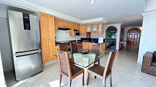 a kitchen with a glass table and a stainless steel refrigerator at Condo Vela Vista 1004 by Kivoya in Nuevo Vallarta