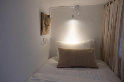 a bedroom with a bed with a pillow on it at Kabalana Surf Hostel in Ahangama