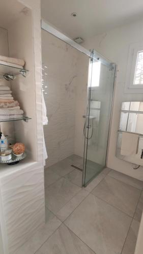 a shower with a glass door in a bathroom at Cosy Orchidée - Villa Élégance, Piscine & Pyrénées "5 étoiles" in Baigts-de-Béarn