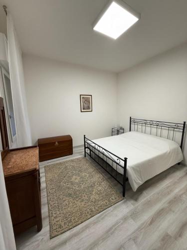 Schlafzimmer mit einem Bett, einem Tisch und einem Teppich in der Unterkunft Elena's apartment - casa gialla in Quartesana