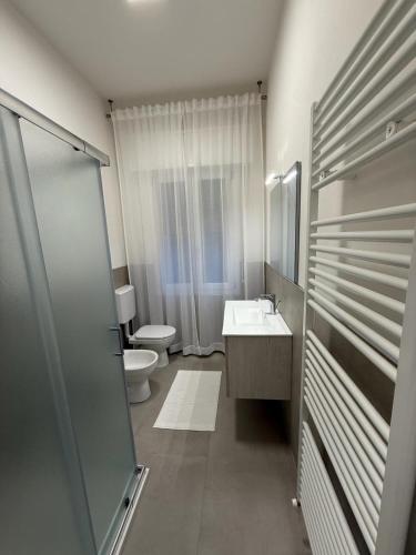 ein weißes Badezimmer mit Toilette und Waschbecken in der Unterkunft Elena's apartment - casa gialla in Quartesana