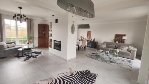 una sala de estar con un sofá y una mesa en Cosy Orchidée - Villa Élégance, Piscine & Pyrénées "5 étoiles", en Baigts-de-Béarn