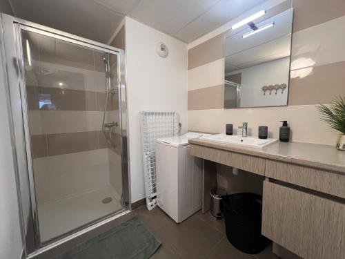 een badkamer met een douche en een wastafel bij Appartement Standing 5mn Village de Noël in Le Barcarès