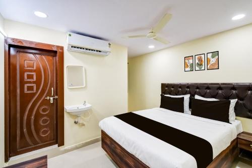 a hotel room with a bed and a bathroom at Hotel O R Square NARSINGI in Gundipet