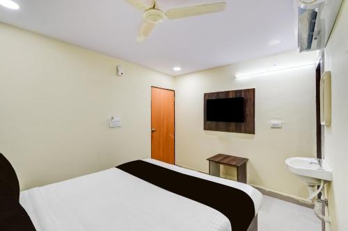 a bedroom with a bed and a sink and a tv at Hotel O R Square NARSINGI in Gundipet
