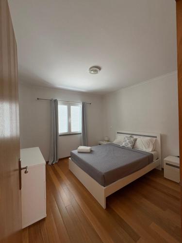 una camera da letto bianca con un letto e una finestra di Island Heart- Family Retreat- Free parking garage a Ribeira Brava