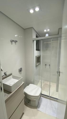 a bathroom with a shower and a toilet and a sink at Studio na Morada do Sol in Piratuba