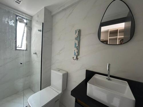 Un baño blanco con lavabo y espejo. en Flat na melhor localização João Pessoa, en João Pessoa