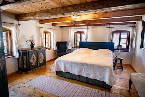een slaapkamer met een groot bed en houten plafonds bij Historisches Baderhaus mit eigenem Saunauhaus in Roding
