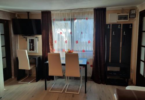 Un comedor con mesa y sillas y una ventana. en Casa Crissio, en Sinaia