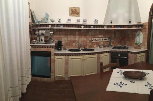 a kitchen with a sink and a table in it at Case Ballerini in Manciano
