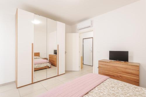 a large mirror in a bedroom with a bed and a television at FaCentro - Free WiFi & Air Conditioning in Faenza