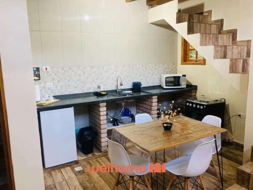 una cucina con tavolo e bancone con lavandino di Chale Manticas aconchego na Serra da Mantiqueira a Costas