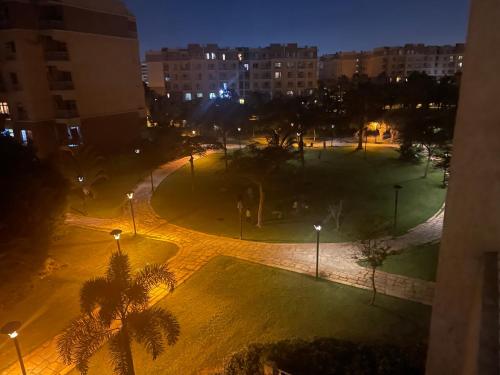 a park with palm trees and street lights at night at Madinaty golden stay in Madinaty