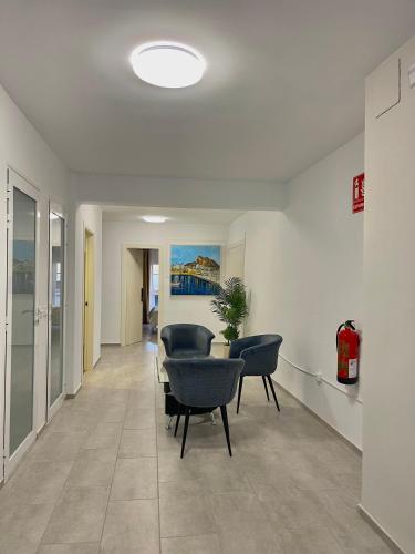 a hallway with chairs and a table in a building at Barocco Rooms Hostel in Alicante