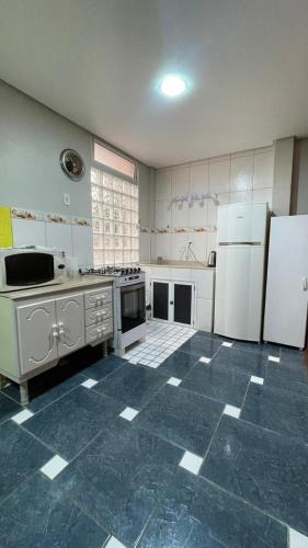 una cucina con elettrodomestici bianchi e pavimento piastrellato blu di Red Office Morada Del Sol 103 a Rio Grande