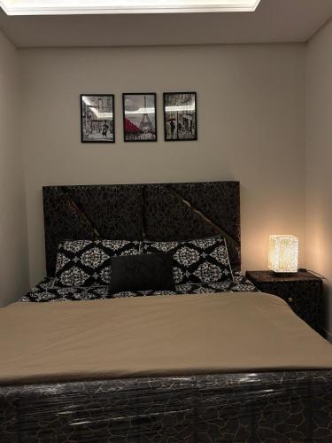 a bedroom with a bed and three pictures on the wall at The little nest in Islamabad