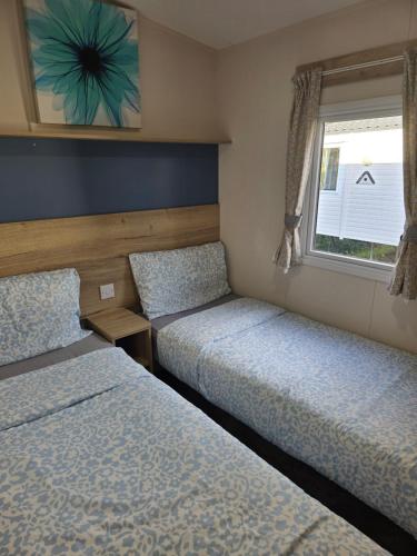 a bedroom with two beds and a window at Laguna- Rockley Park Poole in Poole