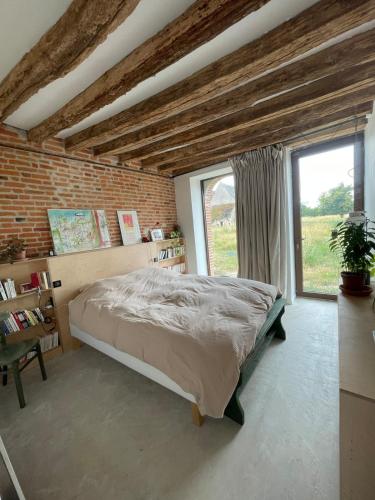 una camera da letto con un letto e un muro di mattoni di Grange transformée a Crucheray