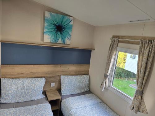 a small bedroom with a bed and a window at Laguna- Rockley Park Poole in Poole