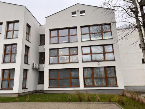 an exterior view of a white building with windows at Tėčio ir Dukters pajūrio apartamentai - Šventojoje in Palanga