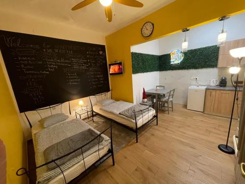 a room with two beds and a chalkboard on the wall at Downtown-Room Zagreb in Zagreb
