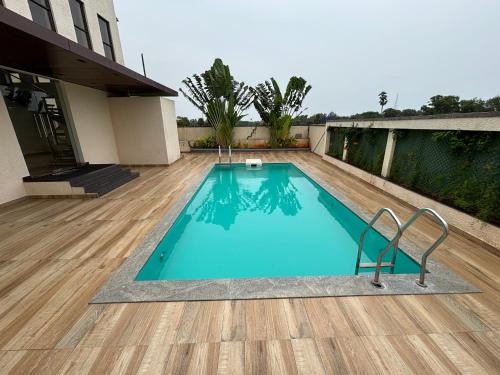 una piscina con una silla junto a una casa en The Sea Garden, en Mahabalipuram