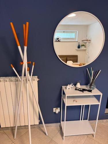 a mirror on a blue wall next to a white table at Appartamento in Centro Living Pescara in Pescara