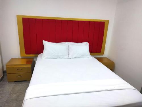 a bedroom with a bed with a red headboard at Hotel La Dorada Sincelejo in Sincelejo