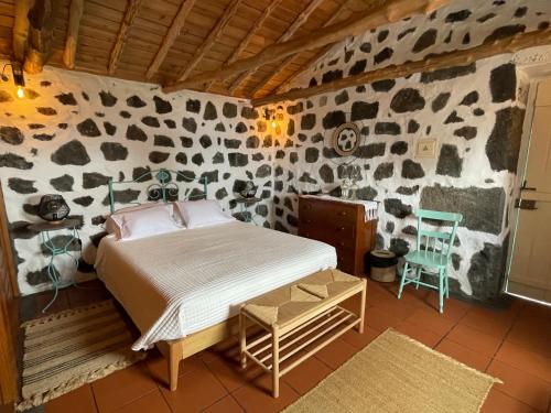 圣罗克杜皮库Casa do Carregadouro - Seaside Retreat的一间卧室，石墙内有一张床